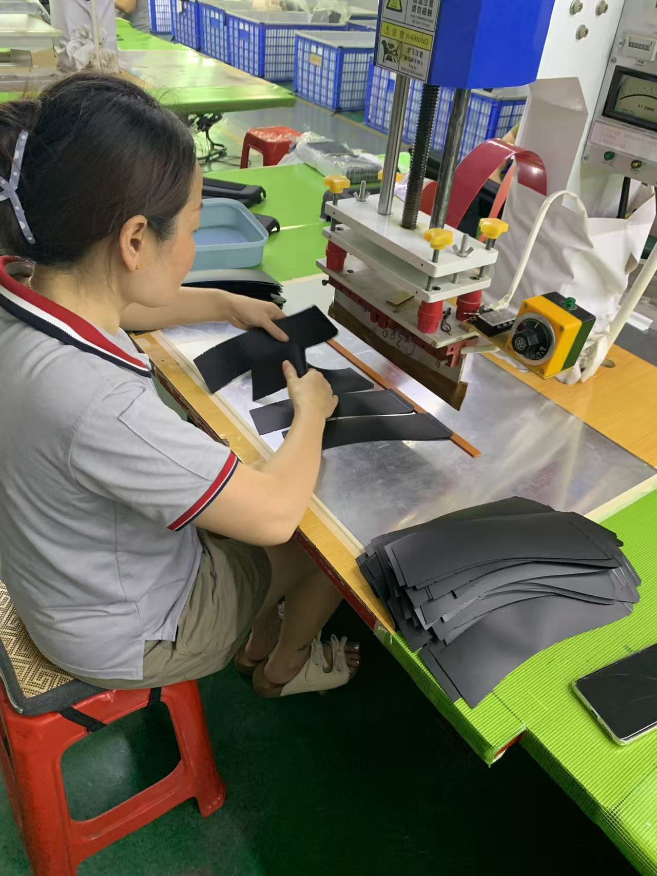 Operator positioning cut TPU panels on a high-frequency welding die